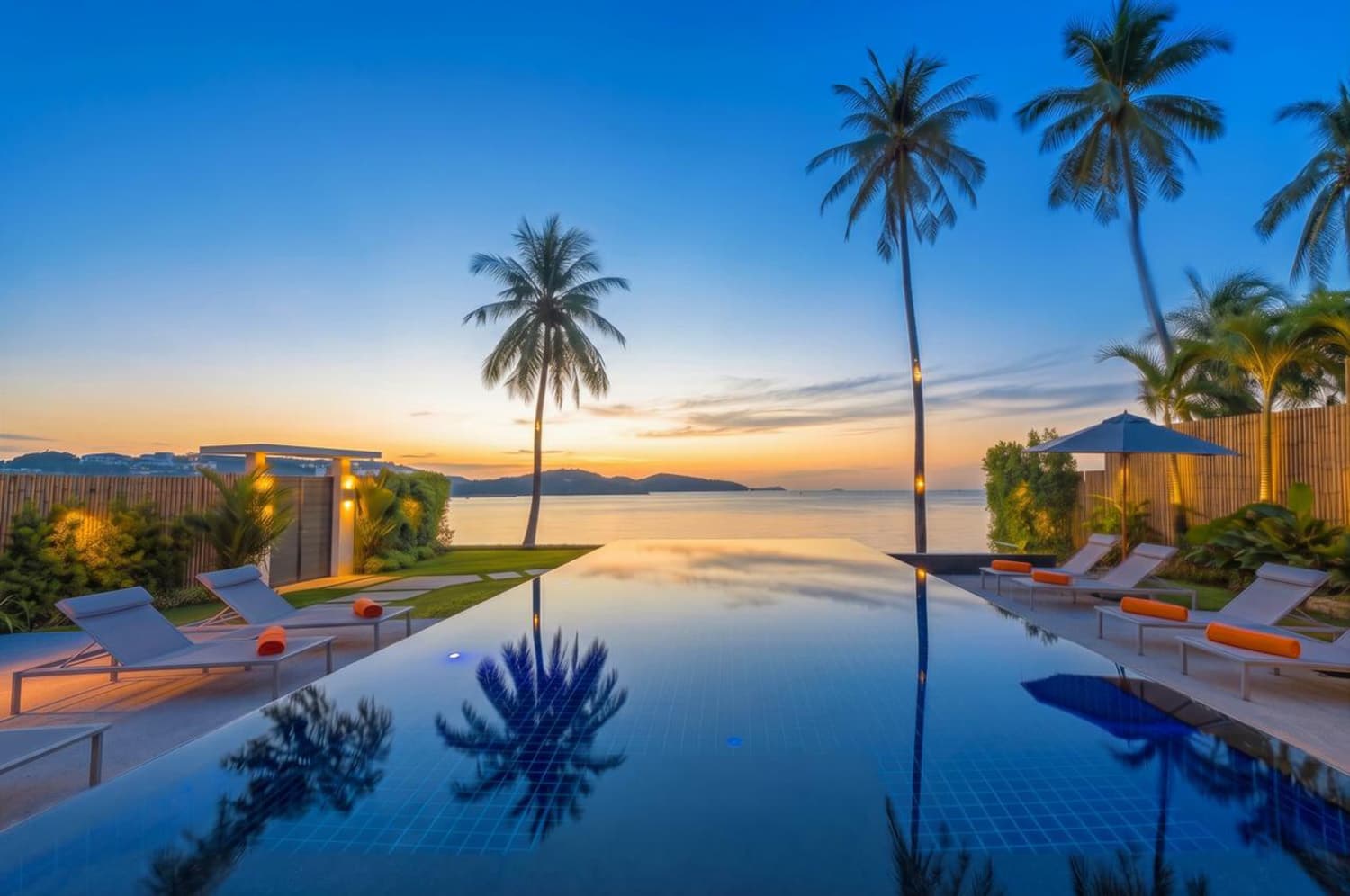 The infinity pool at sunset with palms over Ao Yon Bay
